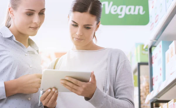 Jonge vrouwen winkelen veganistische producten — Stockfoto