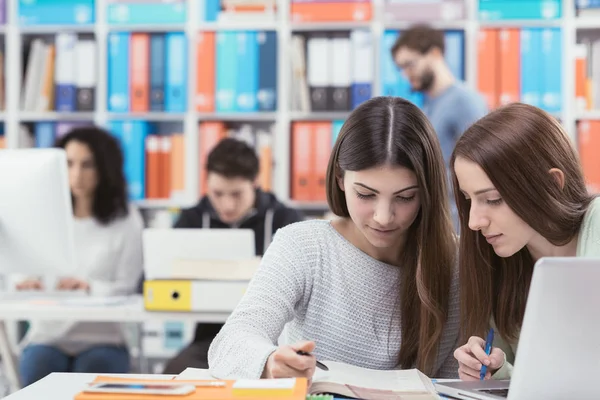 Unge kvinnelige studenter på biblioteket – stockfoto