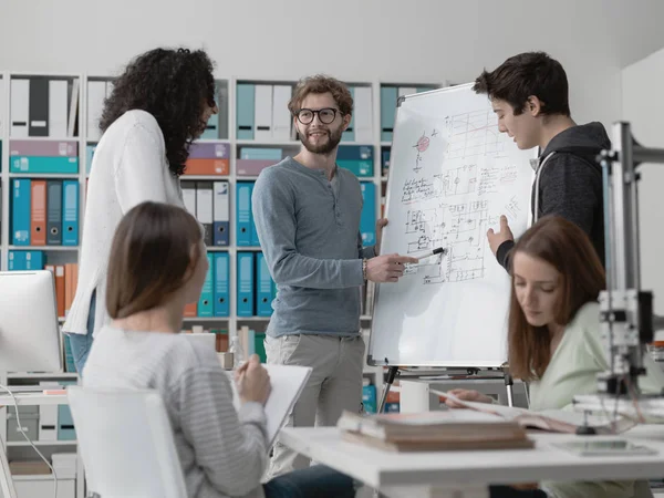 Estudiantes de ingeniería discutiendo ideas en laboratorio — Foto de Stock