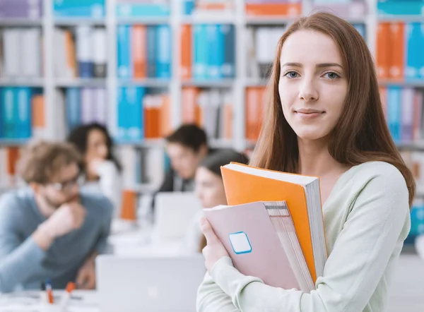 Estudante feminina segurando livros — Fotografia de Stock