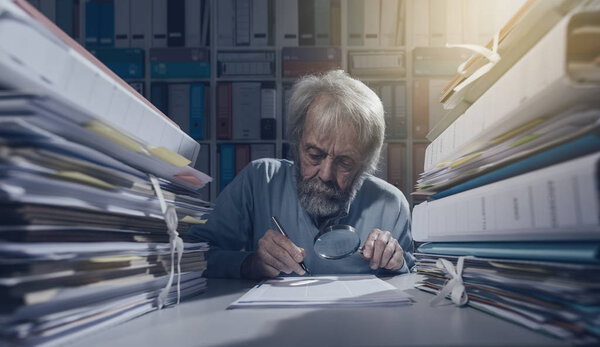 Старший научный сотрудник с помощью лупы
