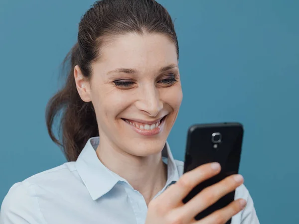 Mulher sorridente se conectando com smartphone — Fotografia de Stock