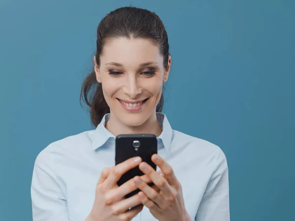 Femme souriante se connectant avec smartphone — Photo