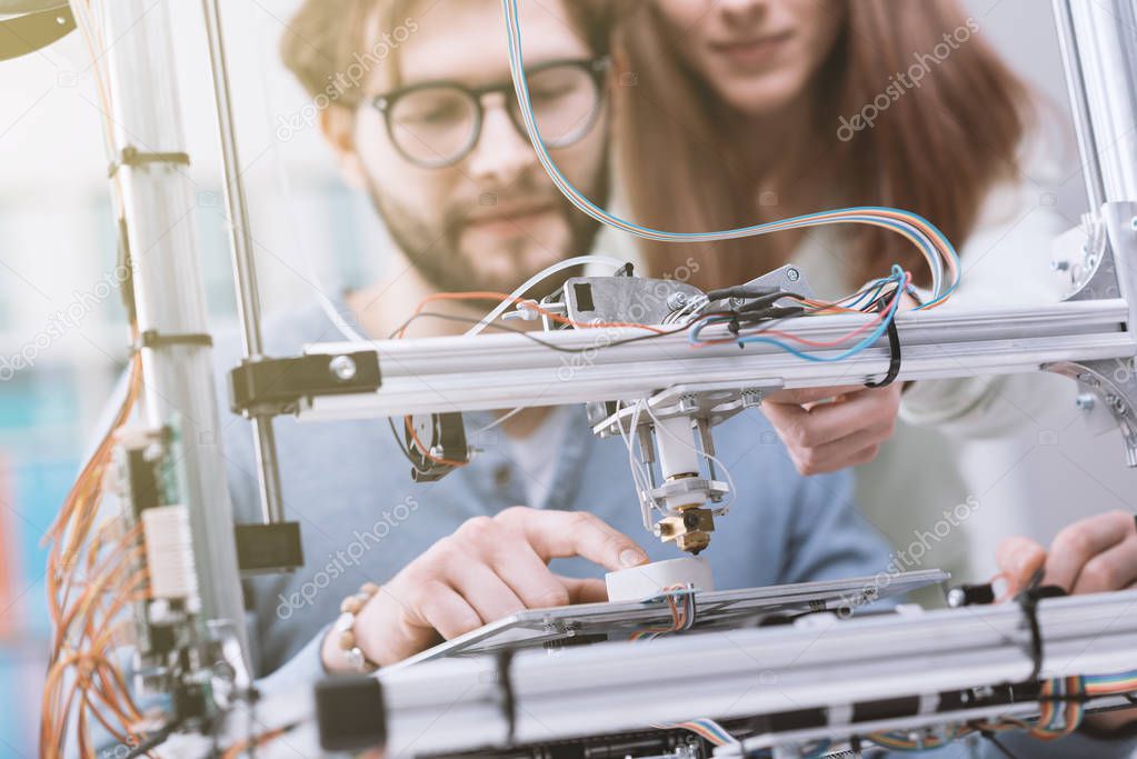 Smiling students using 3D printer