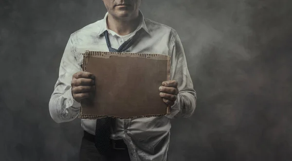 Безработный бизнесмен держит картонную табличку — стоковое фото