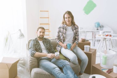 Çift rahatlatıcı ev yenileme sırasında onlar bir koltukta oturan ve bir kahve molası