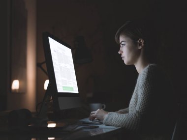 Geceleri bir bilgisayar kullanan kadın
