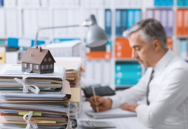 Emlakçı çalışan office ve evrak, ön plan ve ipotek kredi belgeleri şirketten modeli yığınları
