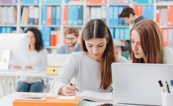 Jóvenes Estudiantes Biblioteca Están Estudiando Juntas Leyendo Libro —  Fotos de Stock