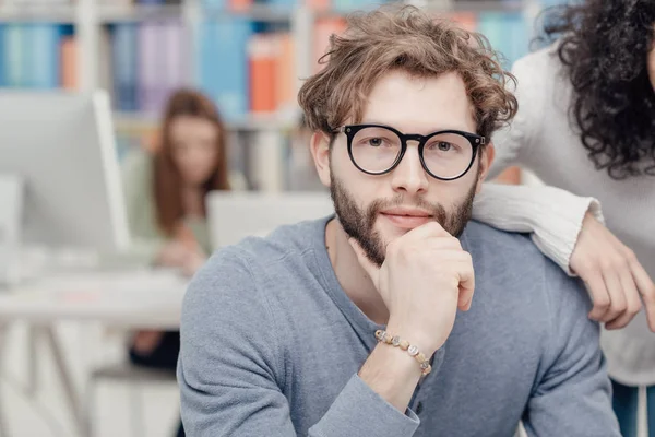 Jovem Sorrindo Hipster Homem Sentado Mesa Seu Colega Está Apoiando — Fotografia de Stock