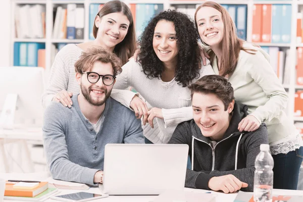Bir dizüstü bilgisayar ile birlikte bağlanma ve gülümseyen, takım çalışması ve eğitim kavramı mutlu öğrenci grubu