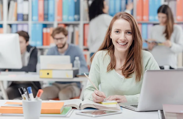 Junge Lächelnde Studentin Sitzt Schreibtisch Und Studiert Ein Buch Studentengruppe — Stockfoto