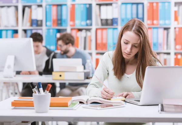 Młoda Kobieta Studentka Siedząc Przy Biurku Połączenie Laptopem Studiując Książkę — Zdjęcie stockowe