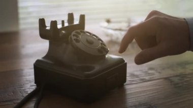 Ahizeyi alıp ve vintage döner bir numara çevirme adam bir masa üzerine telefon arama, bir telefon görüşmesi yapıyor, eller yakın çekim