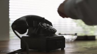 Ahizeyi alıp ve vintage döner bir numara çevirme adam bir masa üzerine telefon arama, bir telefon görüşmesi yapıyor, eller yakın çekim