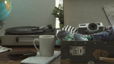 Giyim ve aksesuarları, turizm ve seyahat kavramı ile masa üzerinde seyahat vintage çanta