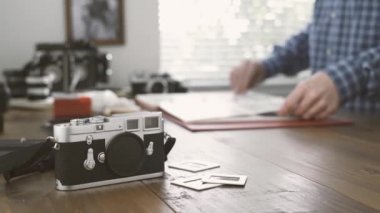 Onun stüdyosunda çalışan profesyonel fotoğrafçı o film negatifleri cilt, vintage fotoğraf makinesi ve ön slaytlarda izliyor