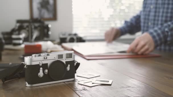 Fotógrafo Profesional Trabajando Estudio Está Viendo Negativos Películas Una Carpeta — Vídeo de stock