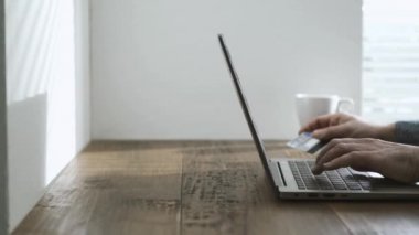 Evde, onun laptop ile çalışan adam online alışveriş yapıyor ve eller e-ödeme, kredi kartı kullanarak kapat