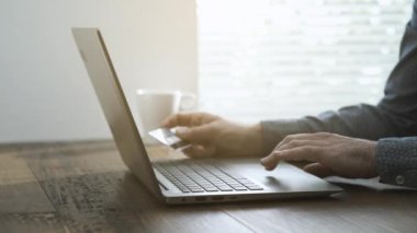 Evde, onun laptop ile çalışan adam online alışveriş yapıyor ve eller e-ödeme, kredi kartı kullanarak kapat
