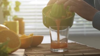 Sağlıklı taze portakal hazırlama kadın sabah kahvaltıda mutfakta meyve suyu, bir bardak, sağlıklı gıda kavramı suyu yağıyor