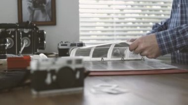 Onun stüdyosunda çalışan profesyonel fotoğrafçı o film negatifleri cilt, vintage fotoğraf makinesi ve ön slaytlarda izliyor