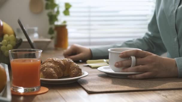朝食を持つ女性の台所で デジタル タッチ画面のタブレットを使用して 彼女はコーヒーを飲むとスライド ページ ライフ スタイルと技術の概念 — ストック動画