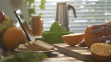 Sağlıklı taze portakal hazırlama kadın sabah kahvaltıda mutfakta meyve suyu, o portakal sıkma ve bir bardak meyve suyu dökerek