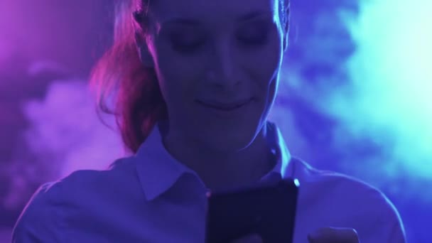 快乐的女人跳舞在迪斯科和社交网络与她的智能手机 她正在聊天和收到一个令人惊讶的信息 — 图库视频影像
