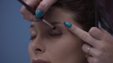 Profesyonel makyaj sanatçı bir modelin göz kapakları, güzellik ve kozmetik kavramı üzerinde göz farı uygulamak