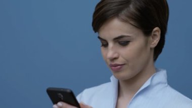 Güzel genç kadın Online onu smartphone ve sosyal ağ ile bağlanma kameraya gülümsüyor