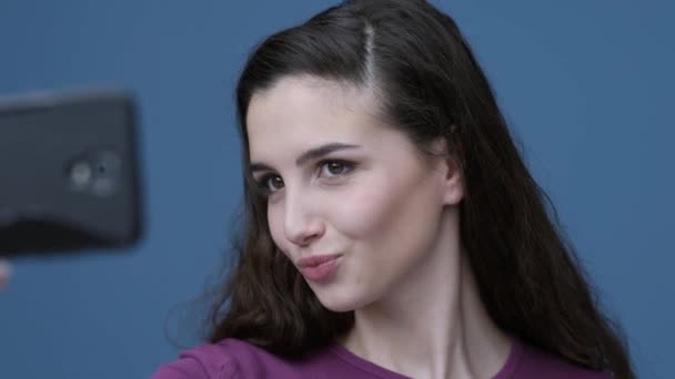 Счастливая Молодая Женщина Делает Селфи Своим Смартфоном Позирует Различными Выражениями — стоковое видео