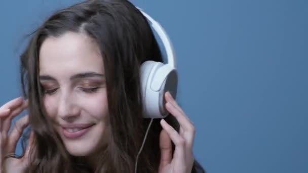 ヘッドフォンを使用して音楽を聴く若者の幸せな女彼女は笑顔とダンス — ストック動画
