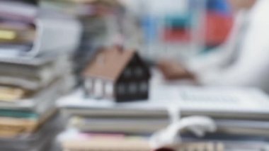 Bir yığın evrak ve gerçek emlakçı masa başında çalışma modeli ev: gayrimenkul, mortgage kredisi ve ekonomi kavramı