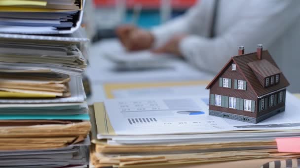 模型房子在一堆文件和房地产代理工作在办公桌上 房地产 按揭贷款和金融概念 — 图库视频影像