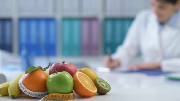 Profesionální výživu, práce v kanceláři a psaní recept dietní, zdravé čerstvé ovoce a Svinovací metr na popředí