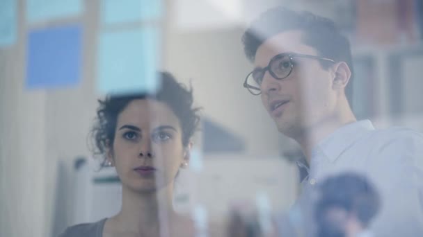 Les gens d'affaires qui travaillent et discutent ensemble au bureau, ils pointent du doigt les notes collantes et les stratégies de planification, le démarrage et le nouveau concept d'entreprise 