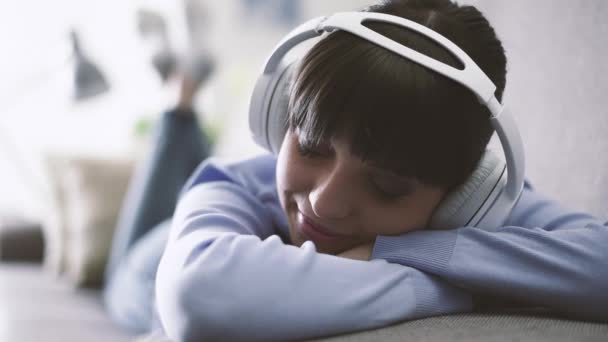 Jovem Deitada Sofá Usando Fones Ouvido Ouvindo Música Casa Conceito — Vídeo de Stock