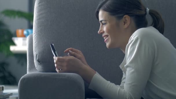 Feliz Mujer Sonriente Relajándose Casa Ella Está Tumbada Sofá Divirtiéndose — Vídeo de stock