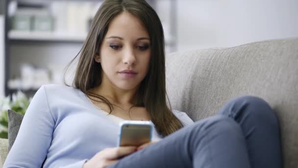 Smiling Young Girl Relaxing Sofa Texting Social Networking Her Mobile — Stock Video