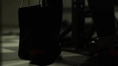 Kadın oturuyor ve eldiven tutarak boks kulübünde