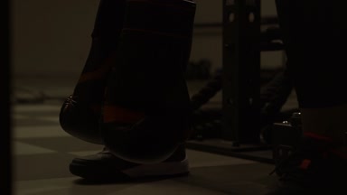 Kadın oturuyor ve eldiven tutarak boks kulübünde