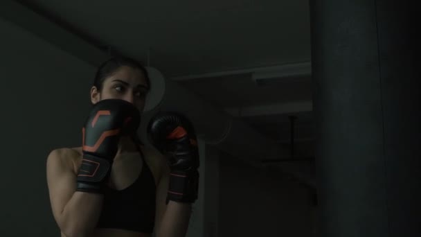 Bokser kobieta uderza worek treningowy na siłowni — Wideo stockowe