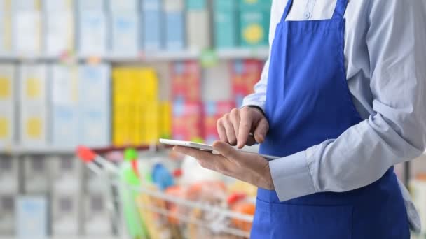 Supermarket clerk using a tablet — Stock Video