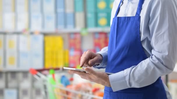 Secretario de supermercado usando una tableta — Vídeo de stock