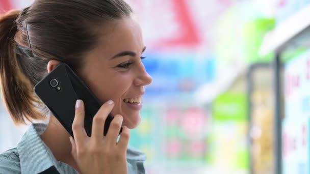 Vrouw aan de telefoon in de winkel — Stockvideo