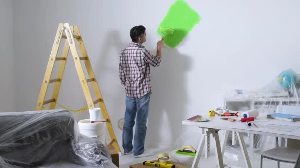 Hombre pintando paredes interiores en casa — Vídeos de Stock