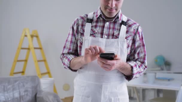 Επαγγελματίας ελαιοχρωματιστής χρησιμοποιώντας ένα smartphone — Αρχείο Βίντεο