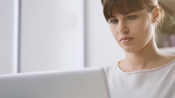 Mujer joven trabajando con un ordenador portátil — Vídeo de stock