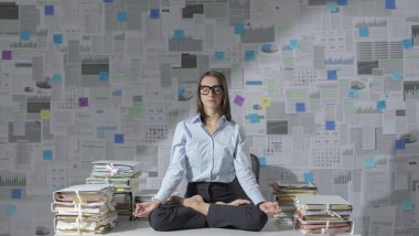 Şirketin iş kadını ofiste meditasyon yapıyor.